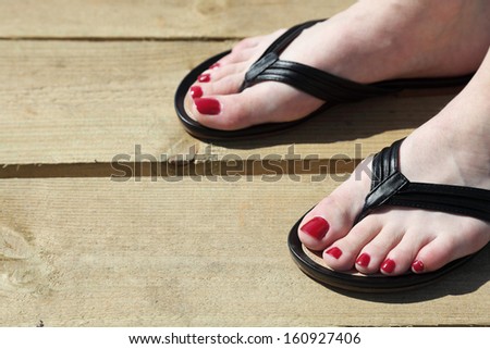 Female feet with flip-flops outdoor red nail
