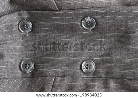 Close detail of a button on a pin striped business suit