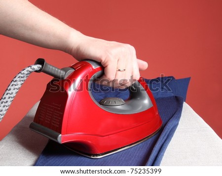 household chores - red iron in hand and navy blue shirt