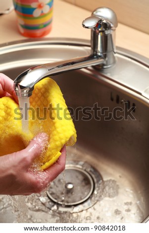 yellow cloth and hands under running water
