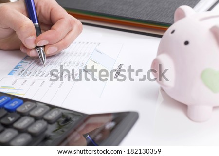 Women calculate expenses with calculator and piggybank