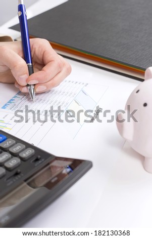 Women calculate expenses with calculator and piggybank