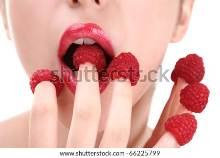 stock photo : Young woman eating raspberries off fingers