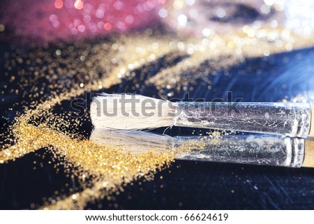 Close-up on brush and shining powder. Very shallow focus on tip of the brush.