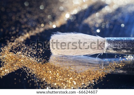 Close-up on brush and shining powder. Very shallow focus on tip of the brush.