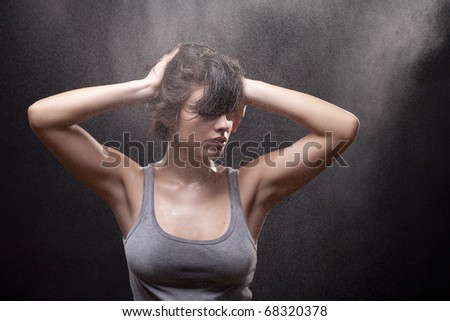 Portrait of beautiful young woman with shirt on black background. Studio photos. Fine spray of water. Post production - without styling filters.