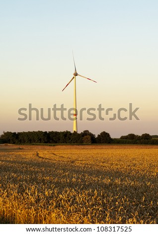 Electric wind turbines on sunset background
