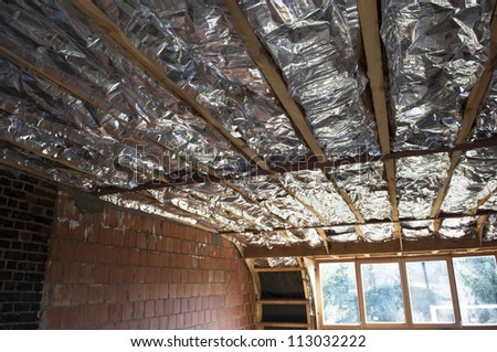 Fiberglass insulation installed in the sloping ceiling of a house.