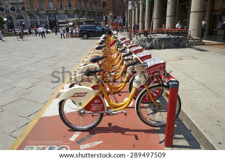 MILAN, ITALY- JUNE 11, 2015: A Row of city bike for rent or Bike sharing station at The Duomo Piazza in Milan. Symbol of mobility in the city