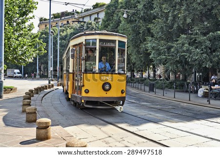 MILAN, ITALY- JUNE 11, 2015: Old vintage Milan Orange Cable Car and his driver on the street of Milan, Italy . Symbol of mobility, ecology and alternative energy