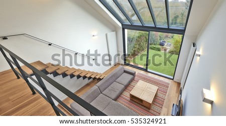 Modern living room with large windows and view on a autumnall garden