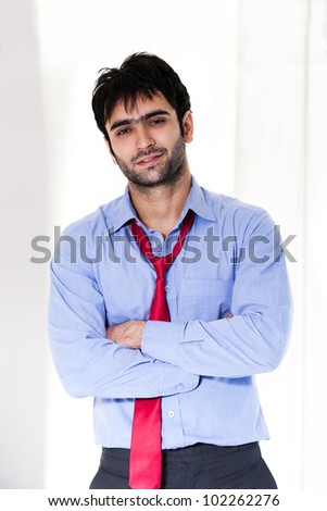 portrait of a happy indian businessman with arms crossed