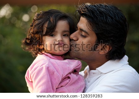 father kissing his daughter, indian man with his one year old daughter