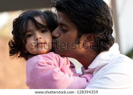 father kissing his daughter, Indian man with his one year old daughter