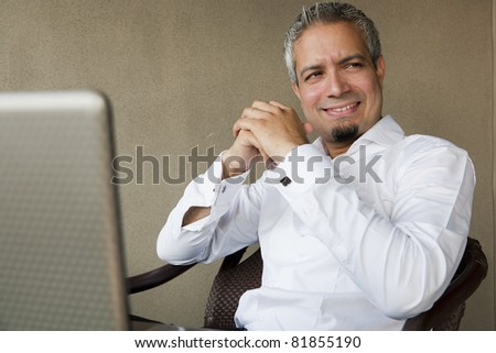 portrait of a happy successful businessman with grey hair working on the laptop, Indian muslim businessman working.