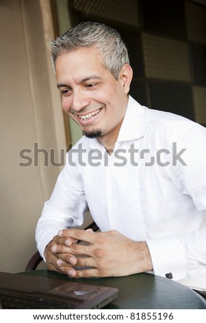 portrait of a happy successful businessman with grey hair working on the laptop, Indian muslim businessman working.