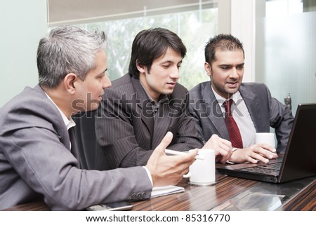 three business men with diversed ethnicity in an official meeting