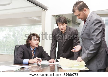 group of young businessmen having a serious and intense discussion in the business meeting.