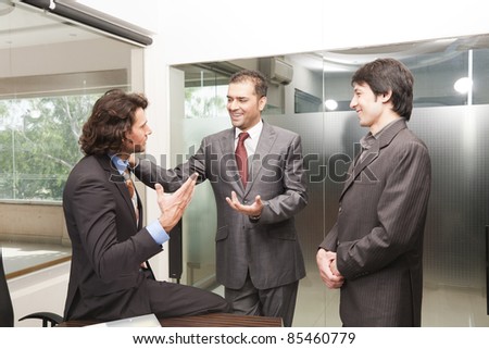 Group of happy businessmen having a casual discussion after the official meeting.