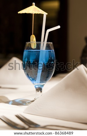 closeup of a blue martini drink on the table with napkins