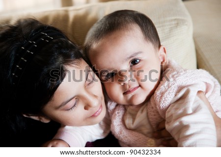 portrait of two little muslim girls, happy little girl holding her baby sister