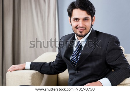 confident Indian businessman sitting on sofa