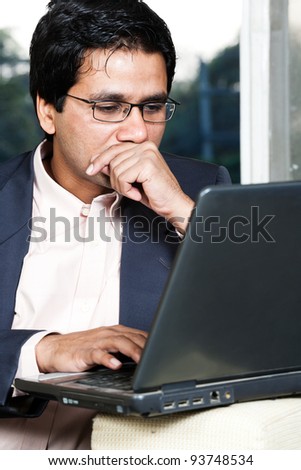 thoughtful Indian businessman working on laptop, businessman lost in deep thoughts
