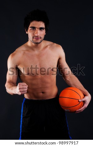 portrait of a handsome and muscular man holding volley ball