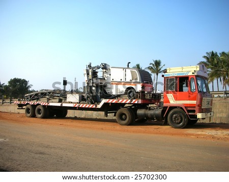 A trailer truck parked on the side of a service road in the suburbs of bangalore city, India.