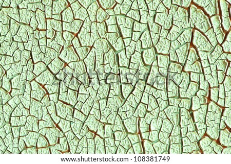 Grunge wall texture background. Green paint cracking off the wall with red paint underneath.