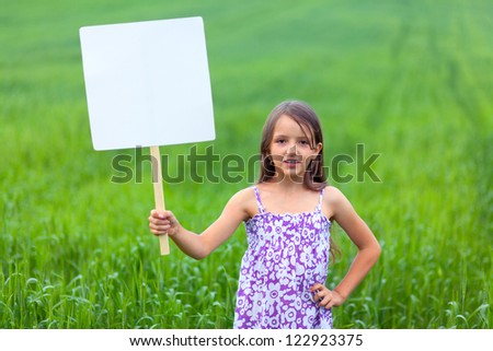 Cute little girl on neutral background holding sign used for your text