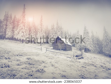 Old farm in the mountains. Colorful winter morning. Retro style.