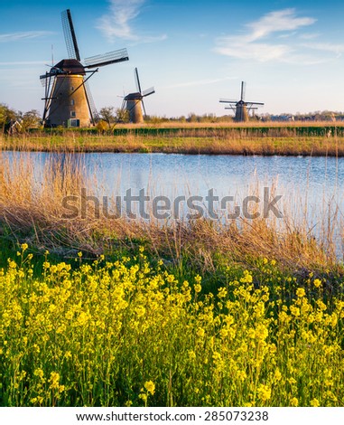 Colorful spring morning on the canal in Netherlands. Dutch windmills at Kinderdijk, an UNESCO world heritage site.