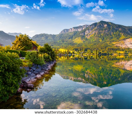 Colorful summer morning on the Grundlsee. Gossl village in the morning mist. Alps, Austria, Europe.