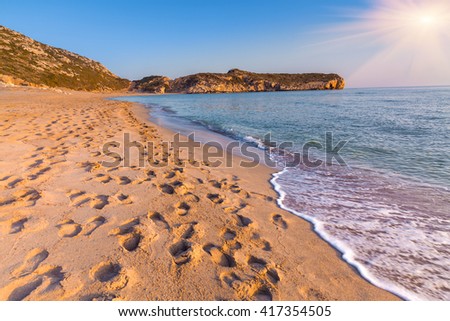 Footprints in the sand on the famous Turkish beach Patara. Colorful sunset in the Turkey,  District of Kas, Antalya Province, Asia. Artistic style post processed photo.