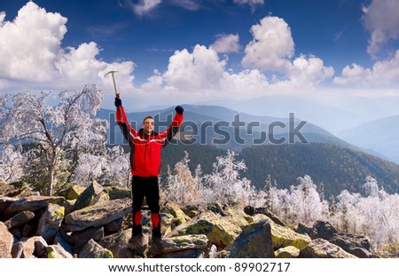 Happy climber with an ice pick in the mountains at November