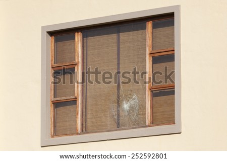 Wooden window frame with one shattered window pane