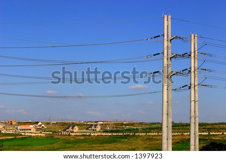 Concrete power line, new houses in the background.
