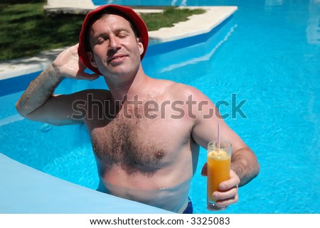 Man in the pool enjoying drink and sunlight