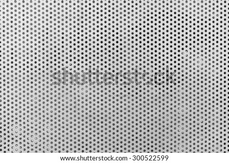 Background sheet of metal covered with lines of circular holes