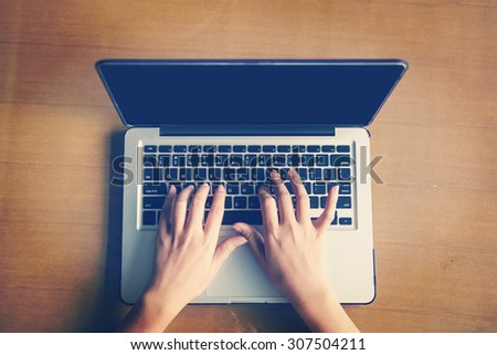 Cropped image of a woman working on  laptop top view