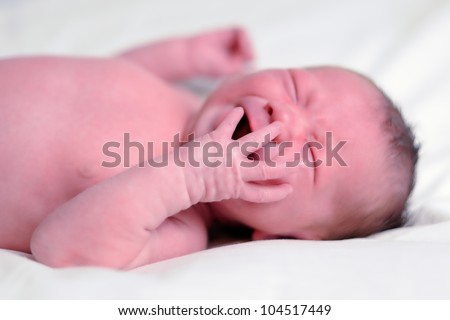 Crying Infant. Three-week old baby boy crying while having his diaper changed. Shallow DOF.
