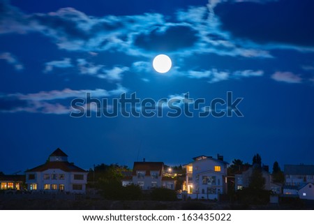 Moon over the river by the town with blue sky and clouds