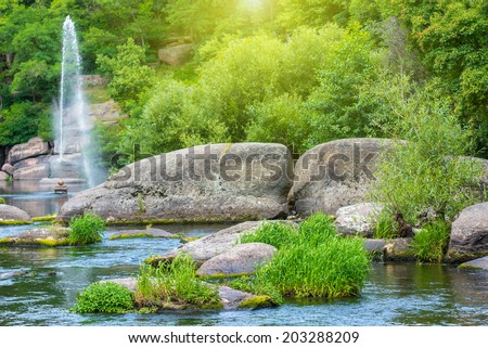 Fountain in the lake between tropical forest. Environment sunny landscape