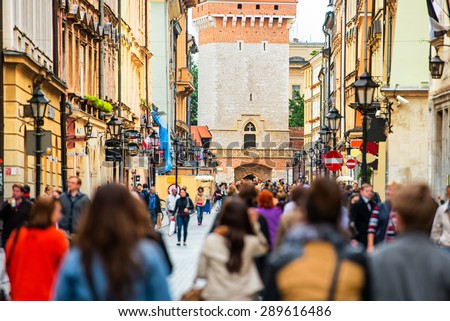 Crowd of anonymous people walking on a busy street. Krakow, Old Town, Poland.