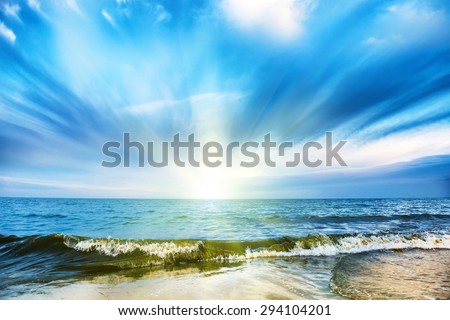 Sunset on tropical beach and blue sea, white clouds on background