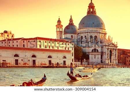 Gondoliers on gondola at Grand Canal in Venice. Basilica Santa Maria della Salute in sunny day. Instagram like filter