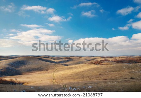 Panoramic landscape with hills and blue sky.