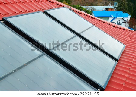 Solar water heating system (geliosystem) on the red house roof.