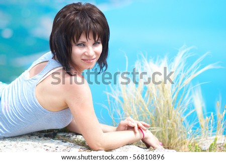Pretty young woman lying on the rock
